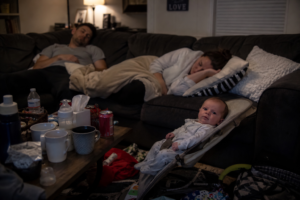 Exhausted parents awake with newborn baby during late night parenting moment