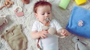 Baby playing with teether toy to soothe baby grinding new teeth discomfort