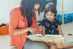 Mom and preschooler reading a picture book together before back to school