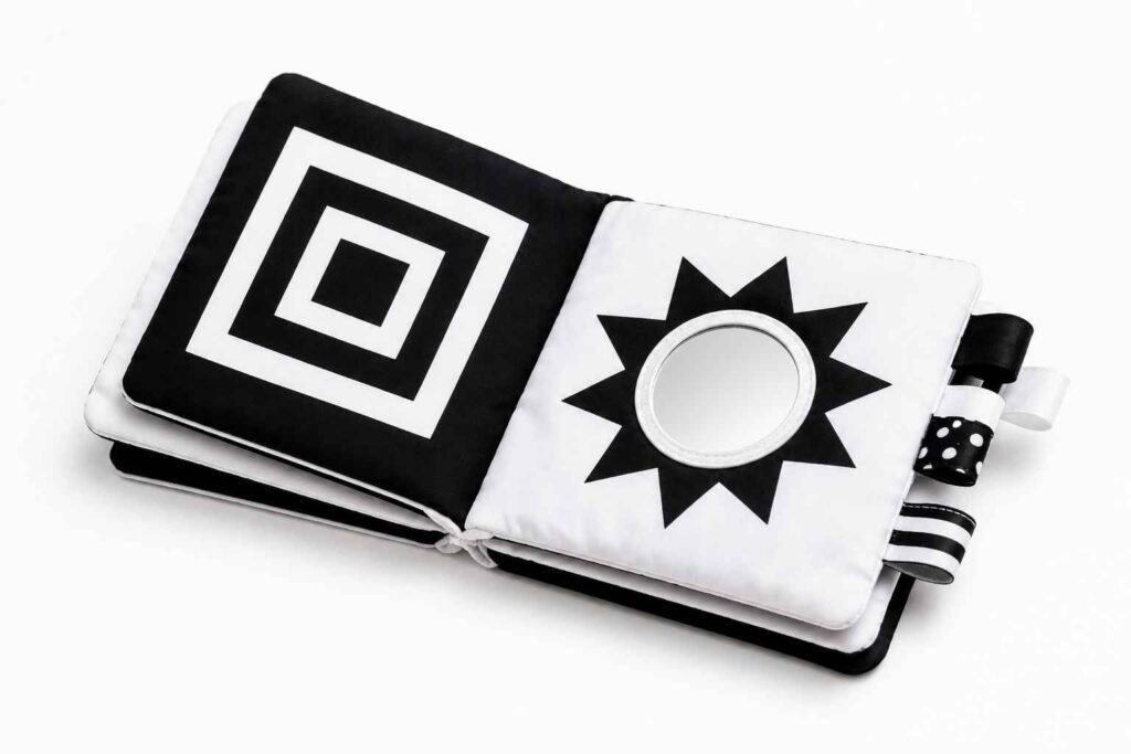 Beiens high contrast black and white soft crinkle book open on white surface showing bold patterns with baby safe mirror and touch and feel textures