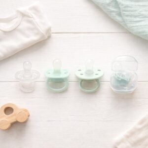 four different newborn pacifier types flat lay on white surface