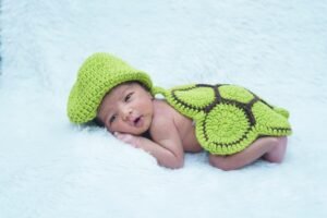 DIY newborn photo setup with floral props surrounding sleeping baby