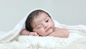 Overhead DIY newborn photo of sleeping baby on bed