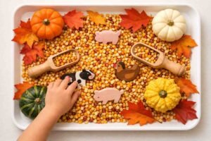 Fall sensory bin preschoolers dried corn autumn leaves mini pumpkins farm animals wooden scoops fine motor activity