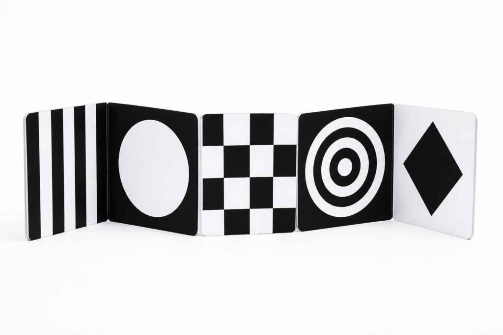 Happy Start high contrast board book standing open on white surface showing black and white geometric patterns for newborn visual development