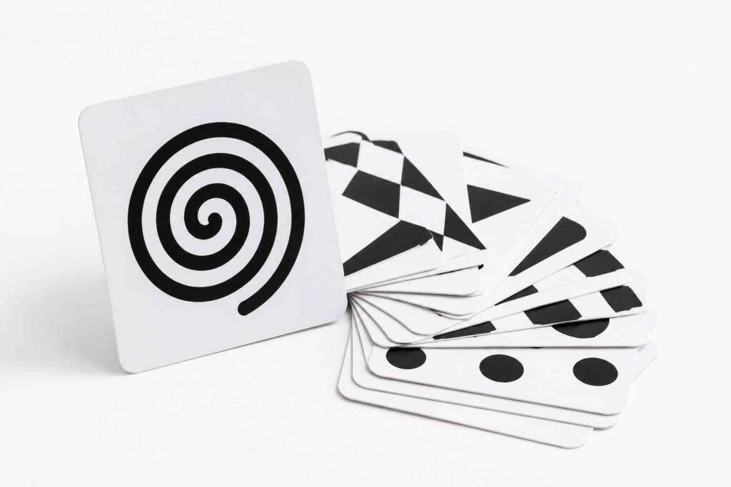Lovevery black and white high contrast flash cards fanned out on white surface for newborn visual tracking practice 0 to 3 months