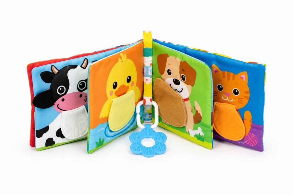 Melissa and Doug Peek-a-Boo soft activity baby book propped open showing bold colorful pages with lift the flap elements and attached teether for 3 month old tummy time