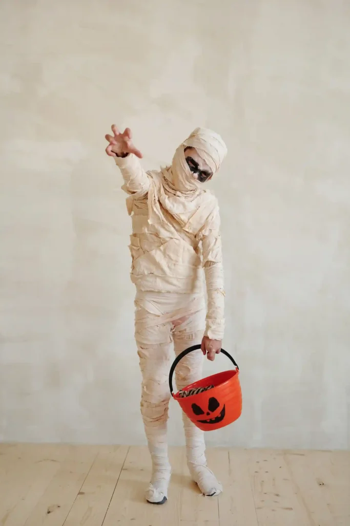 toddler wearing a safe cream mummy costume with secured fabric strips,