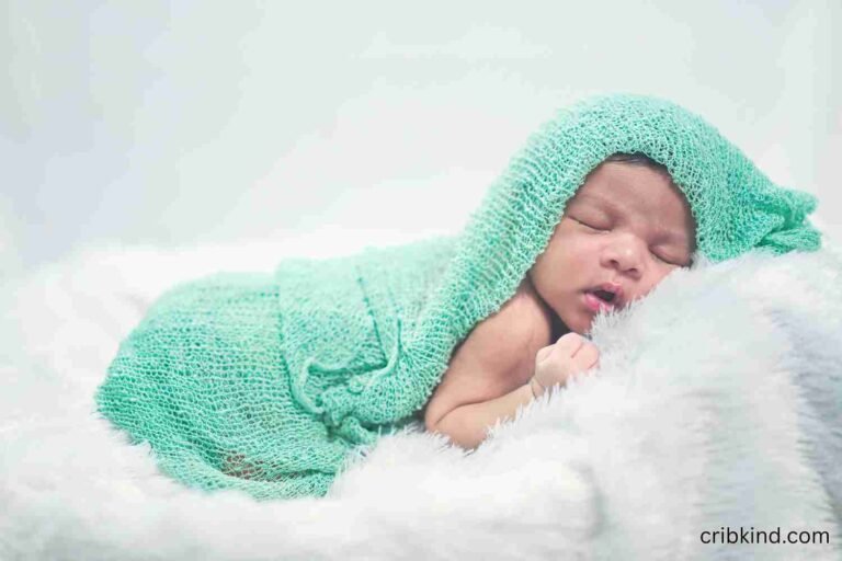 A newborn sleeping in a crib with a feed and sleep schedule visible nearby