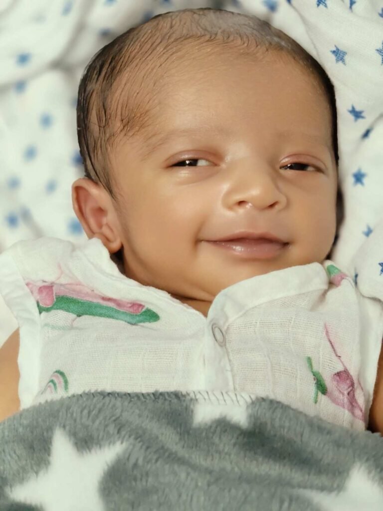 Parent gently lowering a sleeping baby into a crib while the baby begins to wake up