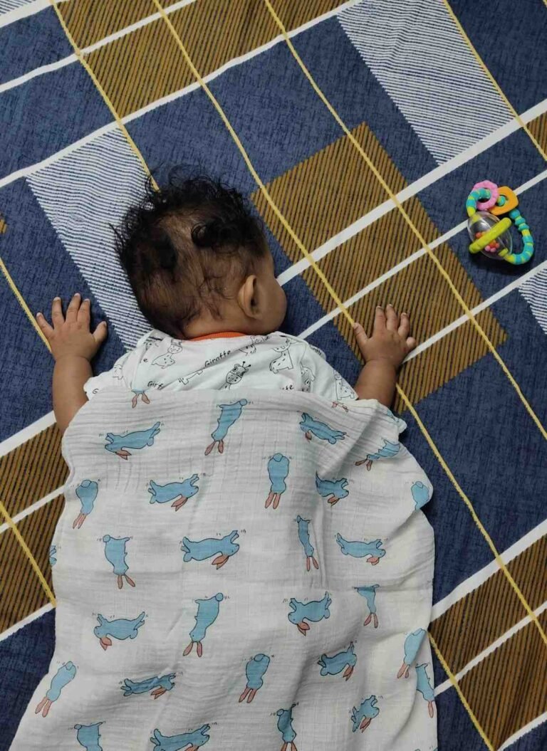 age-by-age guide showing when babies can safely sleep with a blanket from newborn to 18 months